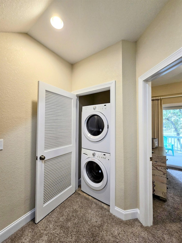 1111 Cambridge Rd Unit 308B, Kill Devil Hills, NC 27948 - laundry area with stacked washing machine and dryer, carpet, baseboards, and a textured wall