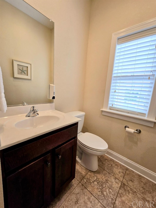 bathroom featuring toilet, tile patterned floors, vanity, and baseboards