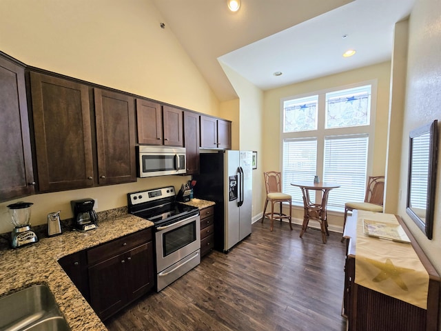 1111 Cambridge Rd Unit 308B, Kill Devil Hills, NC 27948 - kitchen featuring stainless steel appliances, dark brown cabinetry, high vaulted ceiling, dark wood-type flooring, and light stone countertops