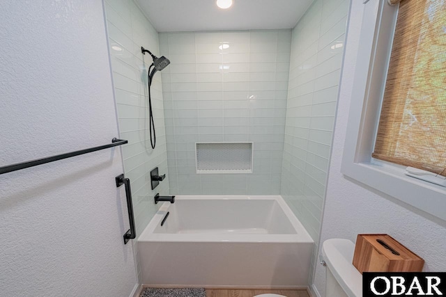 full bath with a textured wall and bathing tub / shower combination