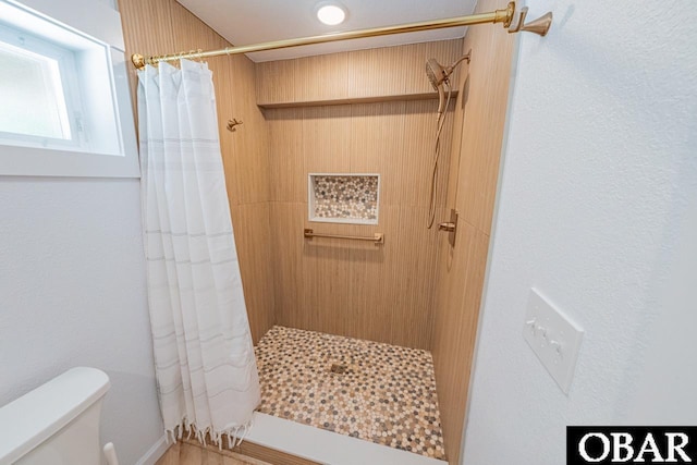 full bath featuring toilet and tiled shower