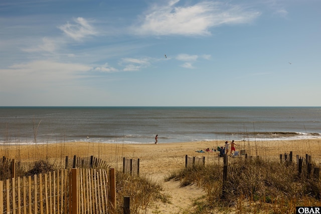 property view of water featuring a beach view and fence