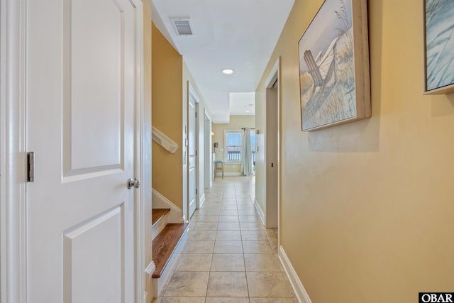 corridor with light tile patterned floors, recessed lighting, visible vents, baseboards, and stairs