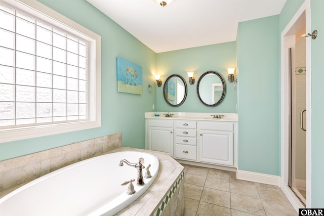 bathroom with a stall shower, a sink, and tile patterned floors