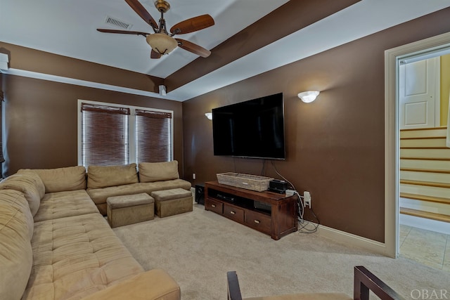 carpeted living room featuring a ceiling fan, visible vents, stairway, and baseboards