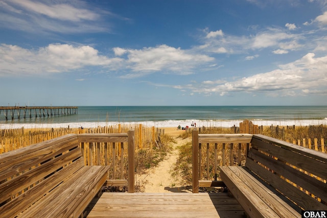 view of home's community with a water view and a beach view