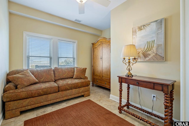 living area featuring baseboards, visible vents, and a ceiling fan