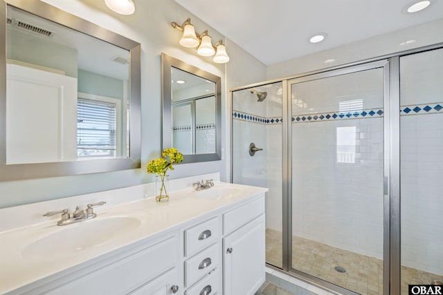 bathroom featuring a stall shower, visible vents, and a sink