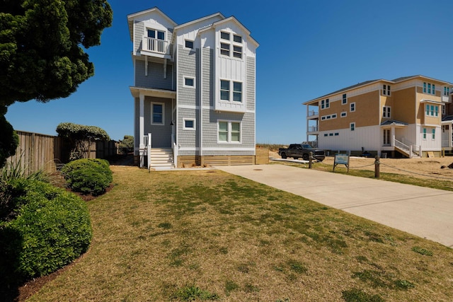 view of front of home featuring a front yard, fence, and driveway