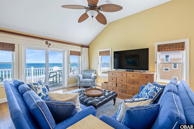 living area featuring ceiling fan, baseboards, vaulted ceiling, and wood finished floors