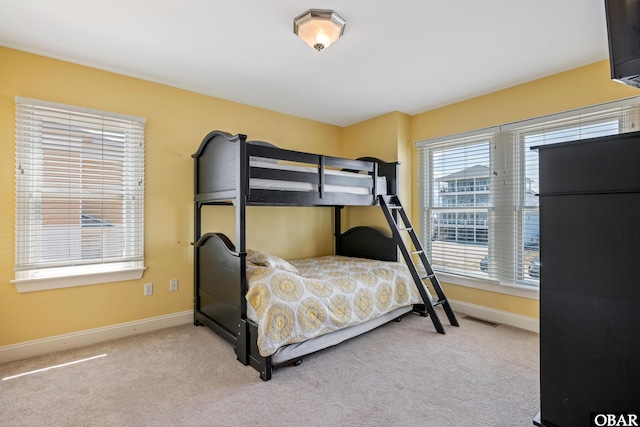 bedroom with visible vents, light carpet, and baseboards