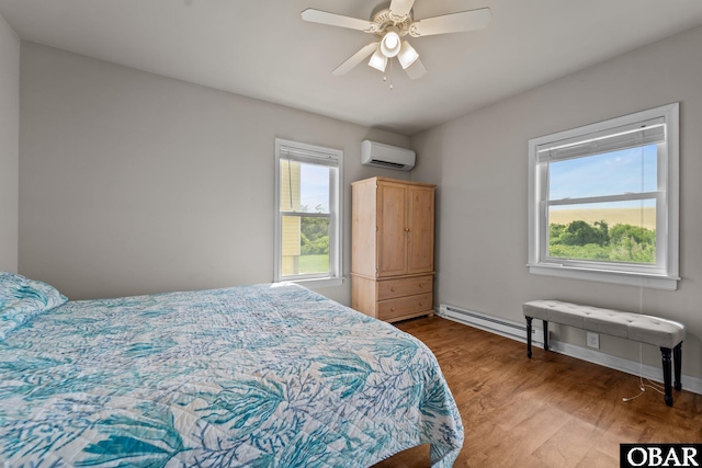118 W Soundside Rd Lot Pt7, Nags Head, NC 27959 - bedroom with baseboard heating, a wall unit AC, wood finished floors, ceiling fan, and baseboards