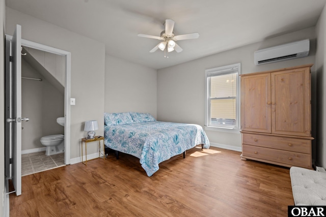 118 W Soundside Rd Lot Pt7, Nags Head, NC 27959 - bedroom with a wall mounted air conditioner, wood finished floors, baseboards, ensuite bath, and a ceiling fan