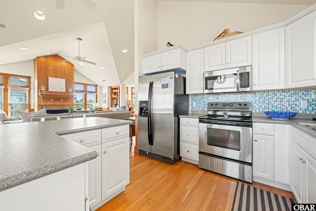 kitchen featuring lofted ceiling, light wood-style flooring, appliances with stainless steel finishes, and open floor plan