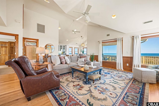 living room with wainscoting, visible vents, and light wood-style floors