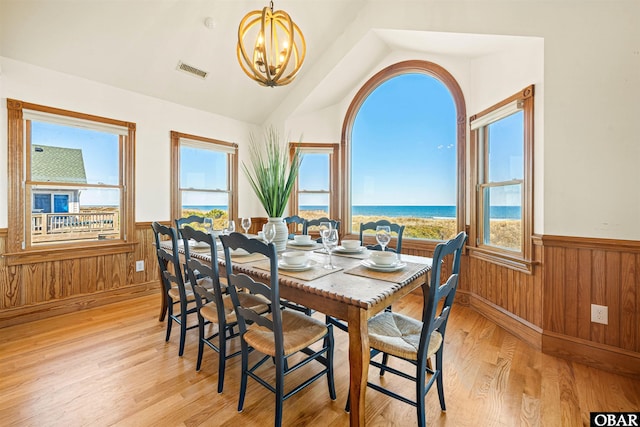 dining area with a chandelier, a wainscoted wall, visible vents, and light wood finished floors