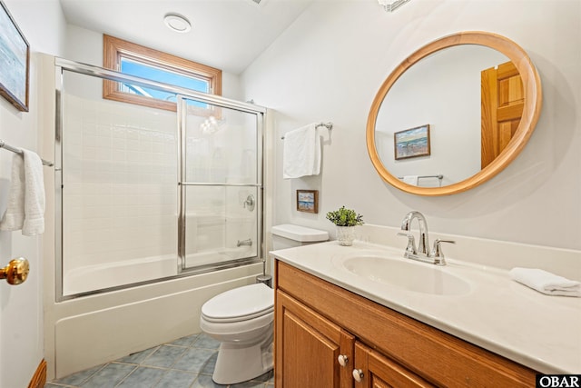 bathroom featuring tile patterned flooring, shower / bath combination with glass door, vanity, and toilet