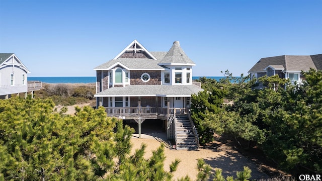 exterior space featuring covered porch, a water view, and stairs