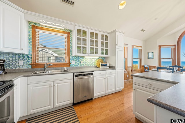 kitchen with visible vents, a wainscoted wall, stainless steel appliances, light wood-style floors, and a sink