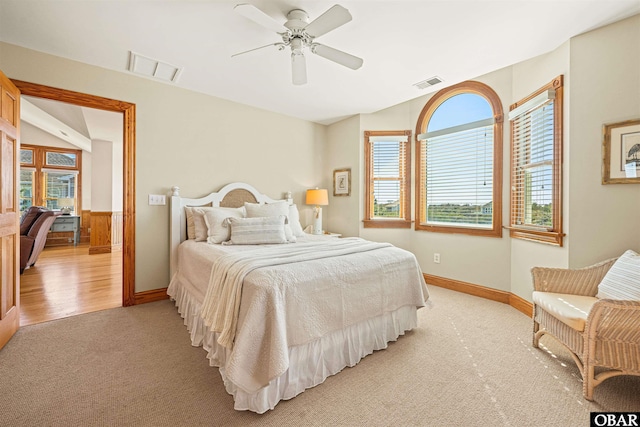 bedroom with multiple windows, visible vents, and light colored carpet