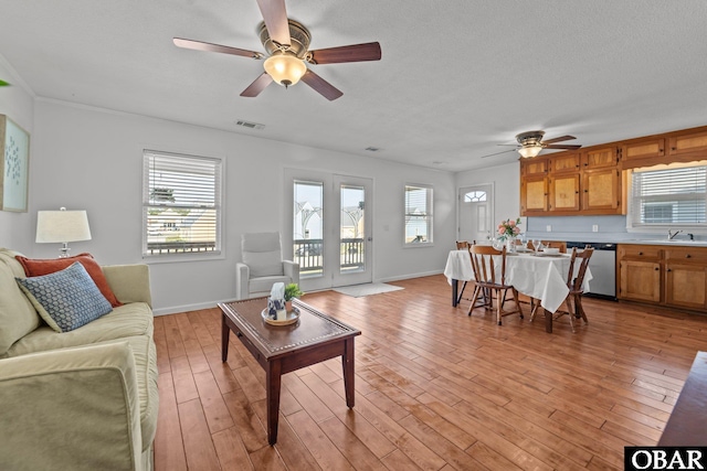 2908 S Meekins Ave Lot 9, Nags Head, NC 27959 - living area featuring ceiling fan, healthy amount of natural light, light wood-style floors, baseboards, and a textured ceiling