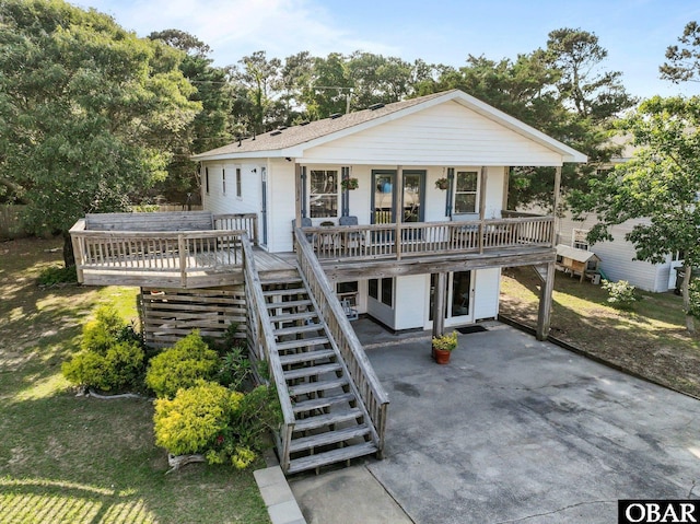 2908 S Meekins Ave Lot 9, Nags Head, NC 27959 - view of front facade with stairway, view of wooded area, and covered porch