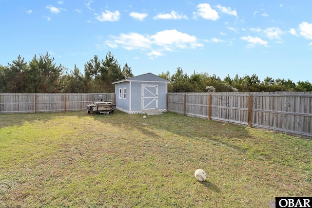 view of yard with an outdoor structure, a shed, and a fenced backyard