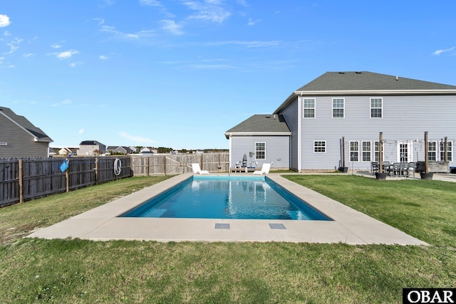 rear view of house featuring a patio, a yard, a fenced backyard, and a fenced in pool