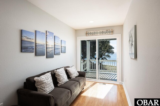 living room featuring wood finished floors, visible vents, and baseboards