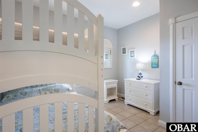 bedroom with light tile patterned floors and baseboards