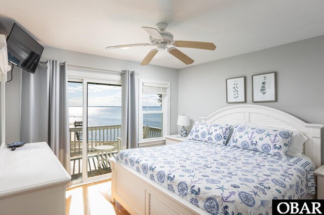 bedroom featuring access to exterior, a water view, and a ceiling fan