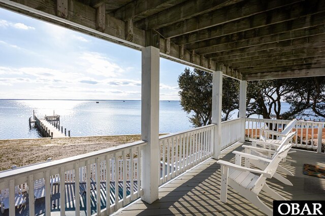 wooden terrace featuring a water view and a boat dock