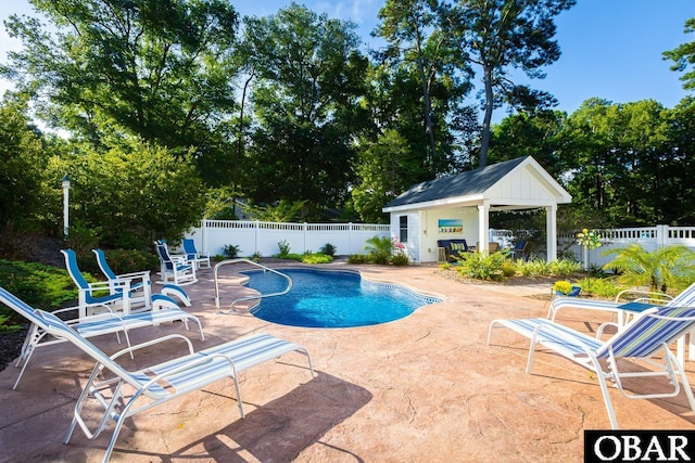 view of pool featuring a fenced in pool, a patio area, fence, and an outdoor structure