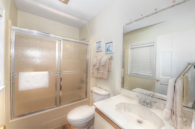 bathroom featuring shower / bath combination with glass door, vanity, and toilet