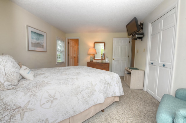 carpeted bedroom featuring a closet and a textured ceiling