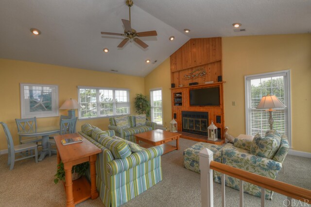 living room with light carpet, baseboards, ceiling fan, a fireplace, and high vaulted ceiling