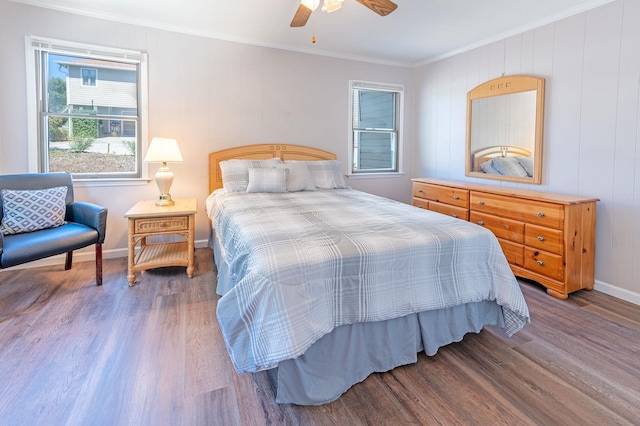 bedroom featuring ornamental molding, wood finished floors, a ceiling fan, and baseboards