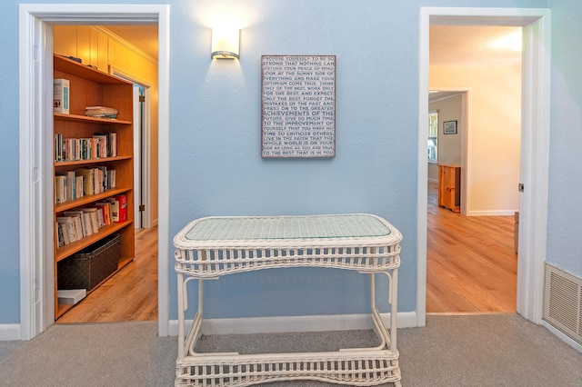 interior space with visible vents, crown molding, and wood finished floors