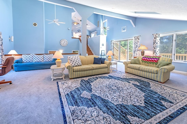 carpeted living area with stairs, high vaulted ceiling, and a textured ceiling