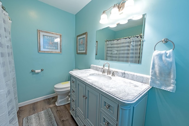 bathroom with curtained shower, toilet, vanity, wood finished floors, and baseboards