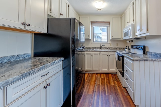 kitchen featuring dark wood-type flooring, white appliances, white cabinetry, and a sink