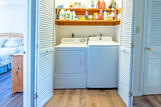 washroom featuring laundry area, light wood finished floors, and washer and dryer