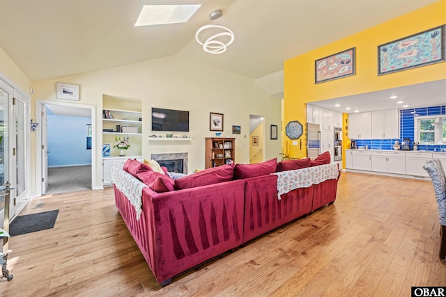 41 Eagles Nest Ln Lot 372, Southern Shores, NC 27949 - living room with a fireplace, light wood-style flooring, a skylight, built in shelves, and high vaulted ceiling