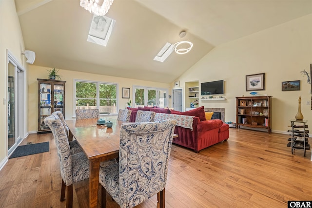 41 Eagles Nest Ln Lot 372, Southern Shores, NC 27949 - dining area featuring high vaulted ceiling, a skylight, light wood-style flooring, a fireplace, and baseboards