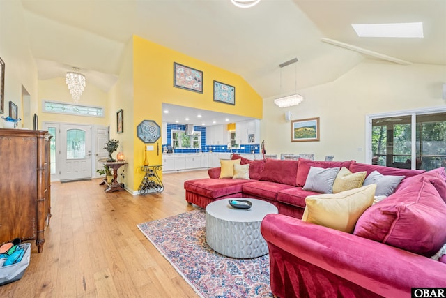 41 Eagles Nest Ln Lot 372, Southern Shores, NC 27949 - living room featuring high vaulted ceiling, light wood-style flooring, plenty of natural light, a skylight, and a chandelier