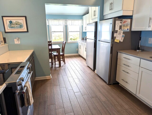 415 British Cemetery Rd Lot # 1 & 2, Ocracoke, NC 27960 - kitchen featuring stainless steel appliances, dark wood finished floors, baseboards, white cabinetry, and light countertops