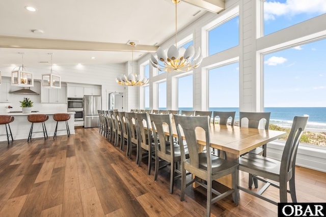 981 Lighthouse Dr Lot 10, Corolla, NC 27927 - dining area featuring a chandelier, dark wood-type flooring, a water view, a high ceiling, and beam ceiling