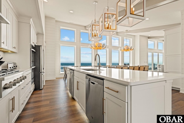 981 Lighthouse Dr Lot 10, Corolla, NC 27927 - kitchen with stainless steel appliances, a kitchen island with sink, a chandelier, dark wood-type flooring, and light countertops
