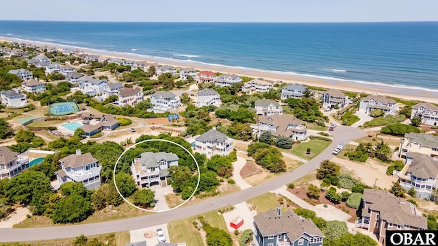 drone / aerial view featuring a view of the beach, a residential view, and a water view