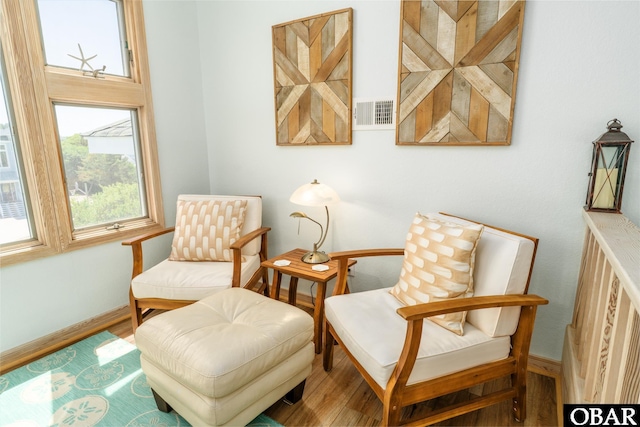 sitting room featuring baseboards, visible vents, and wood finished floors